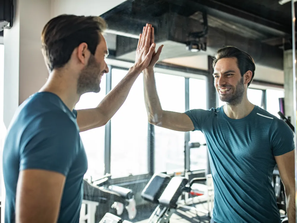 笑顔で鏡に映る自分の姿を見る男性